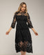 Vestido midi de guipur con transparencias en el escote y las mangas.