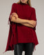 Poncho de punto con flecos en los laterales, cuello perkins y bolsillos.