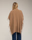 Poncho de punto con flecos en los laterales, cuello perkins y bolsillos.