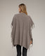 Poncho de punto con flecos en los laterales, cuello perkins y bolsillos.