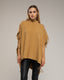 Poncho de punto con flecos en los laterales, cuello perkins y bolsillos.