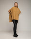 Poncho de punto con flecos en los laterales, cuello perkins y bolsillos.