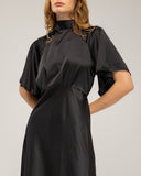 Long satin dress with a turtleneck and bow at the back, fitted at the waist with short flared sleeves