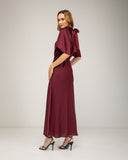 Long satin dress with a turtleneck and bow at the back, fitted at the waist with short flared sleeves