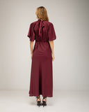 Long satin dress with a turtleneck and bow at the back, fitted at the waist with short flared sleeves