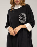 Vestido de punto fino oversize con manga francesa y detalle de flor de crochet, cuello y puños bicolor