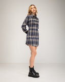 Vestido camisero corto de cuadros con detalles de cordones y botones. Tiras en la cintura