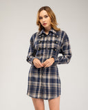 Vestido camisero corto de cuadros con detalles de cordones y botones. Tiras en la cintura