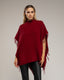 Poncho de punto con flecos en los laterales, cuello perkins y bolsillos.