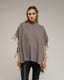 Poncho de punto con flecos en los laterales, cuello perkins y bolsillos.
