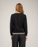 Fine-knit sweater with a crew neck and topstitching at the neck, cuffs, and hem